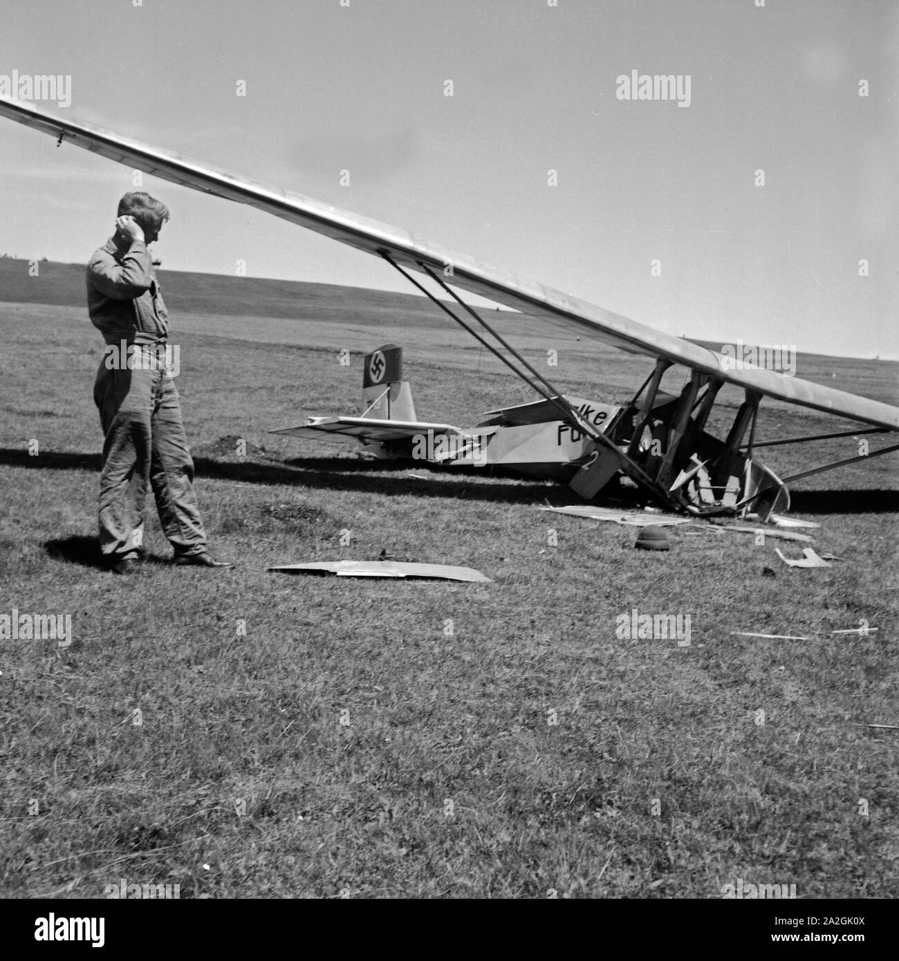 Ein Angestellter der Wasserkuppe Reichssegelflugschule unertsuchen abgestürztes bei Fulda ein Segelflugzeug, Deutschland 1930 er Jahre. Un membre du personnel de l'Reichssegelflugschule pour vol à voile Wasserkuppe près de Fulda l'examen de l'épave d'un avion, l'Allemagne des années 1930. Banque D'Images