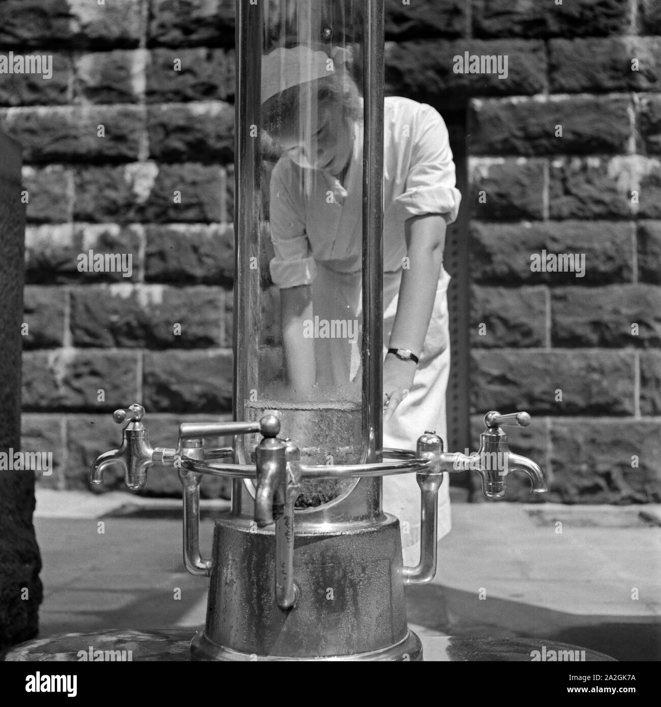 Eine Krankenschwester Kurbad im Bad Homburg von une Heilwasserquelle, 1930er Jahre Deutschland. Une infirmière sur un puits d'eau de guérison à Bad Homburg spa resort, Allemagne 1930. Banque D'Images