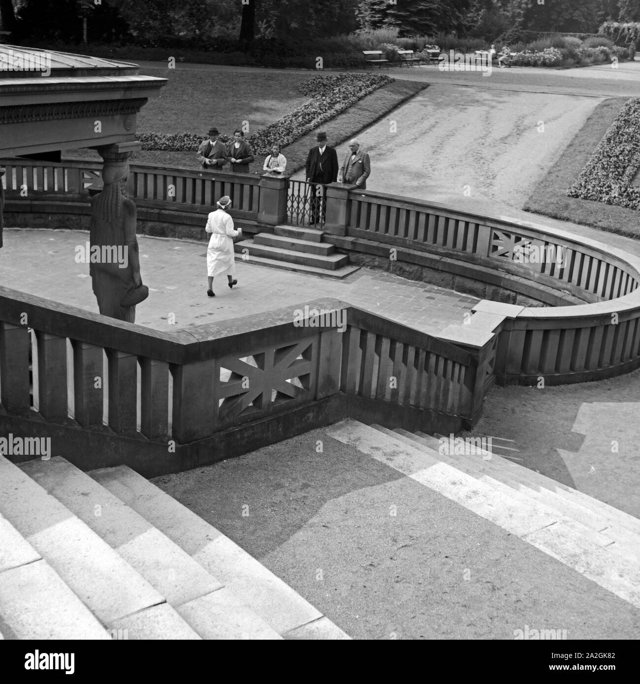 Eine Krankenschwester bringt Kurgästen à Bad Homburg Wasser aus der Heilquelle, Deutschland 1930 er Jahre. Une infirmière apportant de l'eau d'un spa de printemps médicinales réduite à Bad Homburg, Allemagne 1930. Banque D'Images