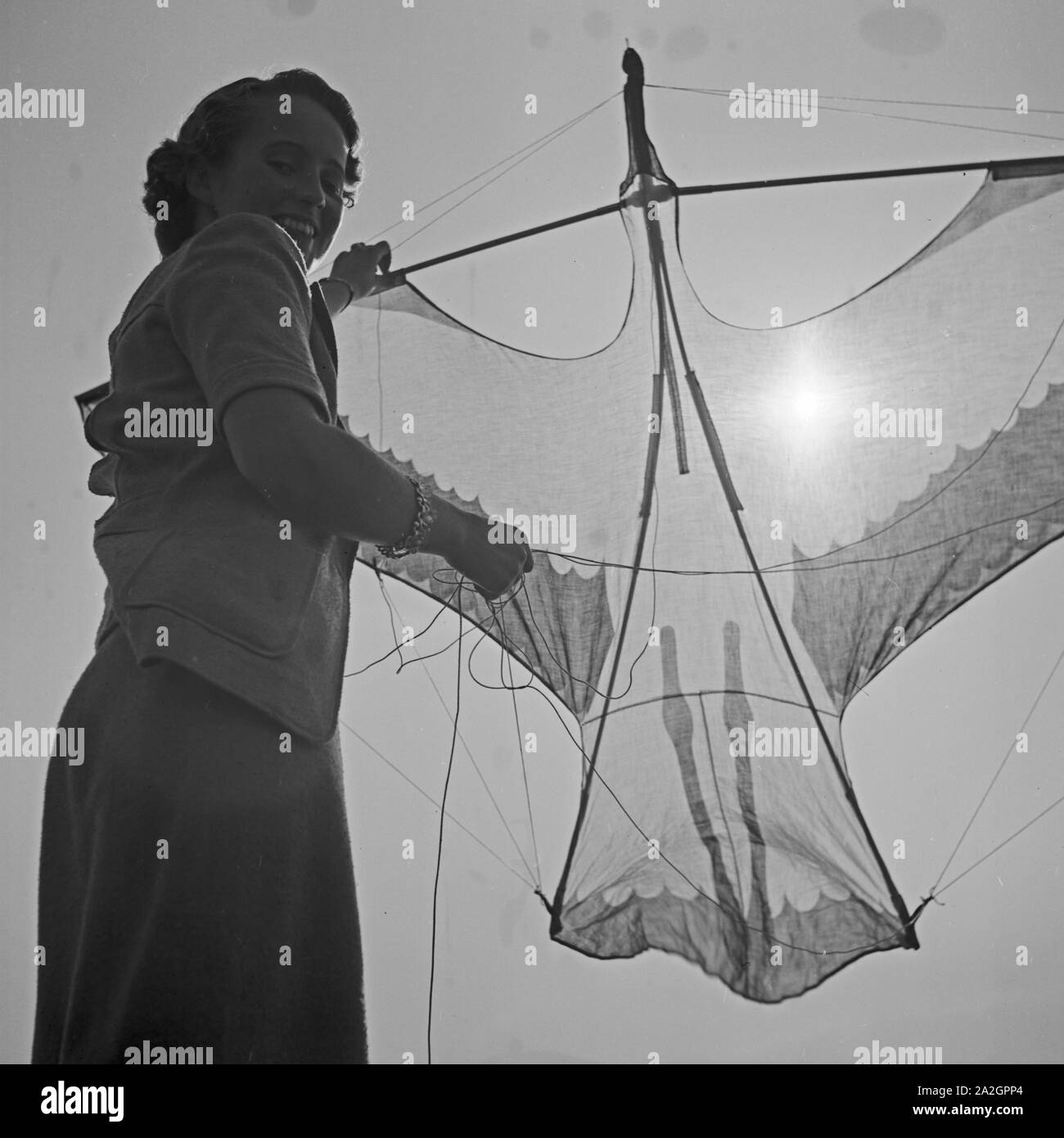 Eine junge Frau mit einem Lenkdrachen, 1930er Jahre Deutschland. Une jeune femme avec un cerf-volant pilotable, Allemagne 1930. Banque D'Images