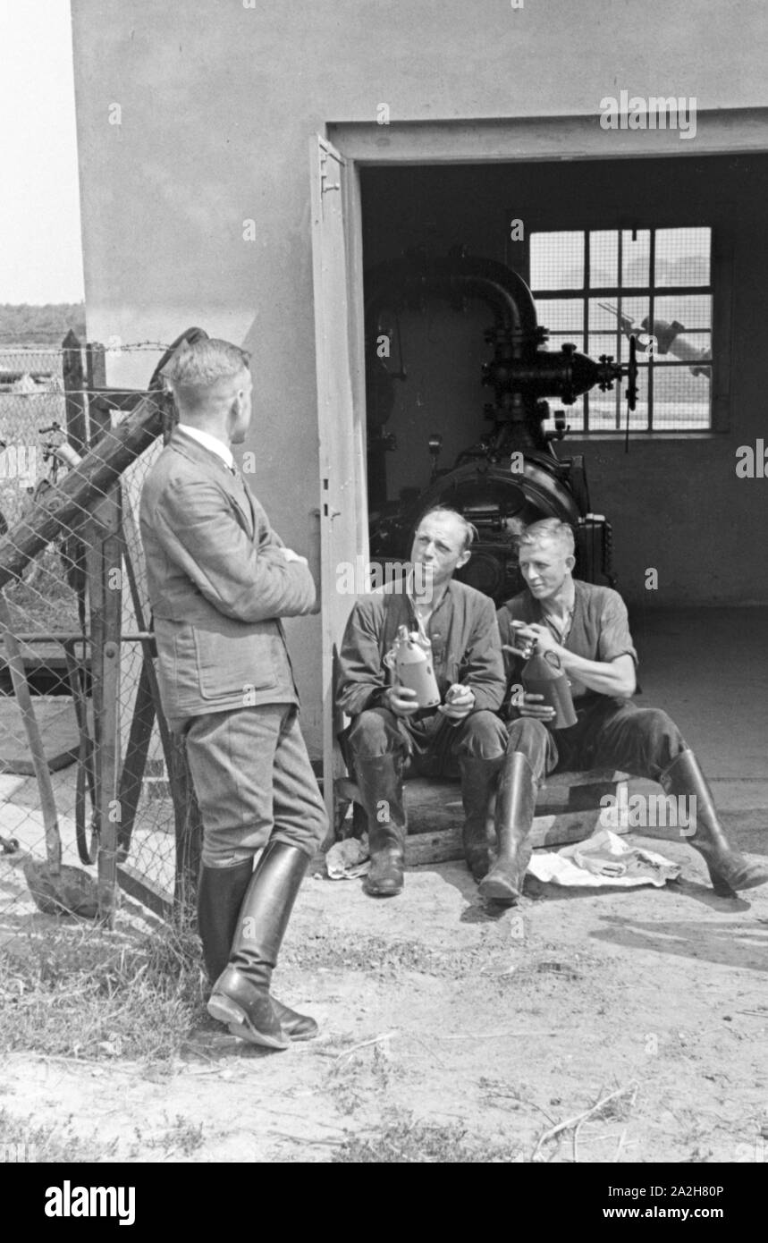 Ein für die im Pumpenhaus Regenanlage Kartoffelacker landwirtschaftlichen Einsatz bei einem, Deutschland 1930 er Jahre. Une cabane de pompage pour le réseau sprinkleur dans son usage agricole à un champ de pommes de terre, de l'Allemagne des années 1930. Banque D'Images