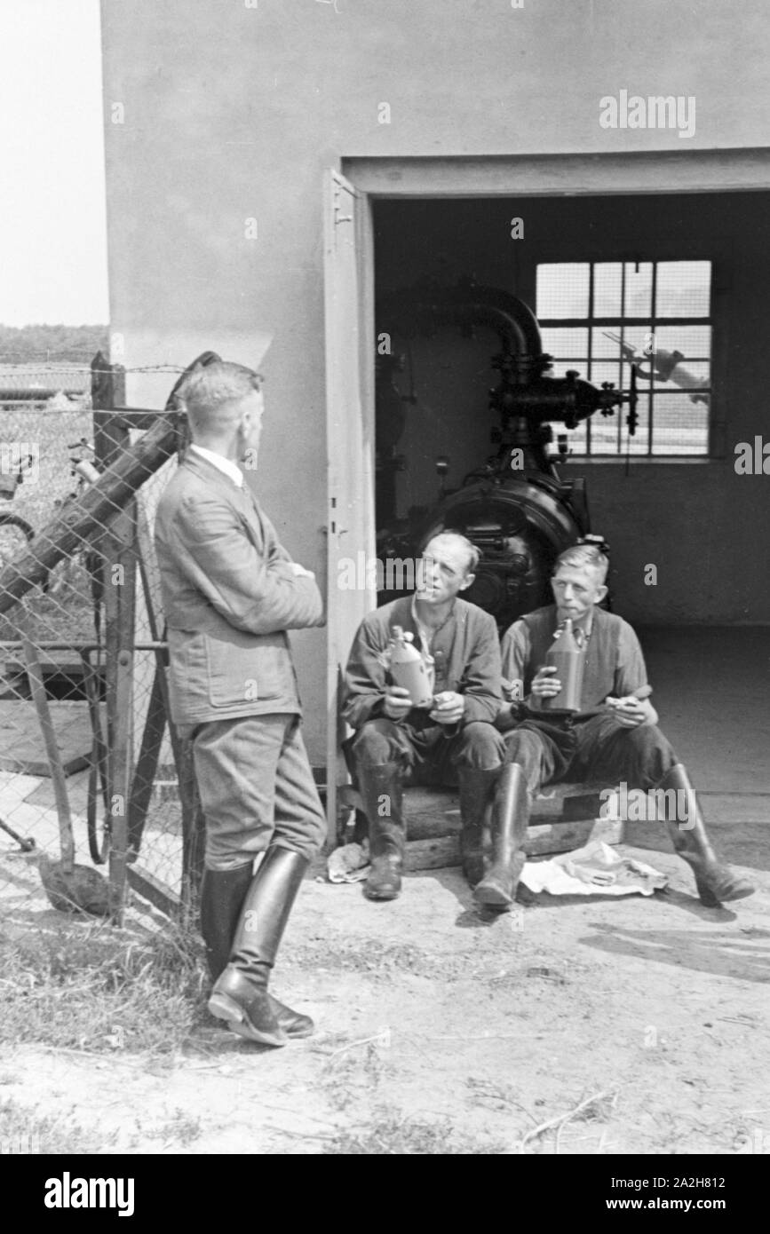 Ein für die im Pumpenhaus Regenanlage Kartoffelacker landwirtschaftlichen Einsatz bei einem, Deutschland 1930 er Jahre. Une cabane de pompage pour le réseau sprinkleur dans son usage agricole à un champ de pommes de terre, de l'Allemagne des années 1930. Banque D'Images