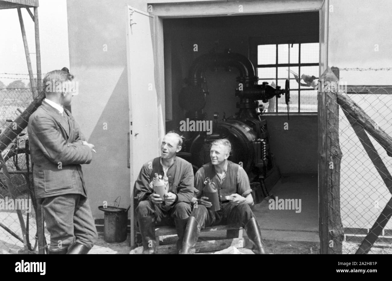 Ein für die im Pumpenhaus Regenanlage Kartoffelacker landwirtschaftlichen Einsatz bei einem, Deutschland 1930 er Jahre. Une cabane de pompage pour le réseau sprinkleur dans son usage agricole à un champ de pommes de terre, de l'Allemagne des années 1930. Banque D'Images
