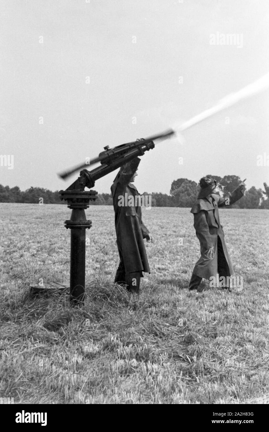 Eine im Regenanlage Kartoffelacker landwirtschaftlichen Einsatz bei einem 1930er Jahre, Deutschland. Un système de gicleurs dans son usage agricole à un champ de pommes de terre, de l'Allemagne des années 1930. Banque D'Images