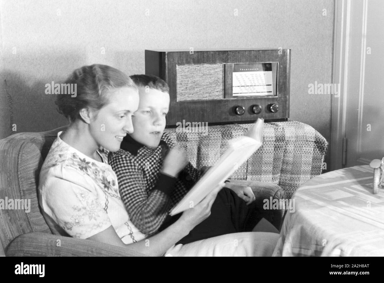 Mutter und Sohn Radio hören im Wohnzimmer, Deutschland 1930 er Jahre. La mère et le fils de l'écoute de la radio à la salle de séjour, de l'Allemagne des années 1930. Banque D'Images