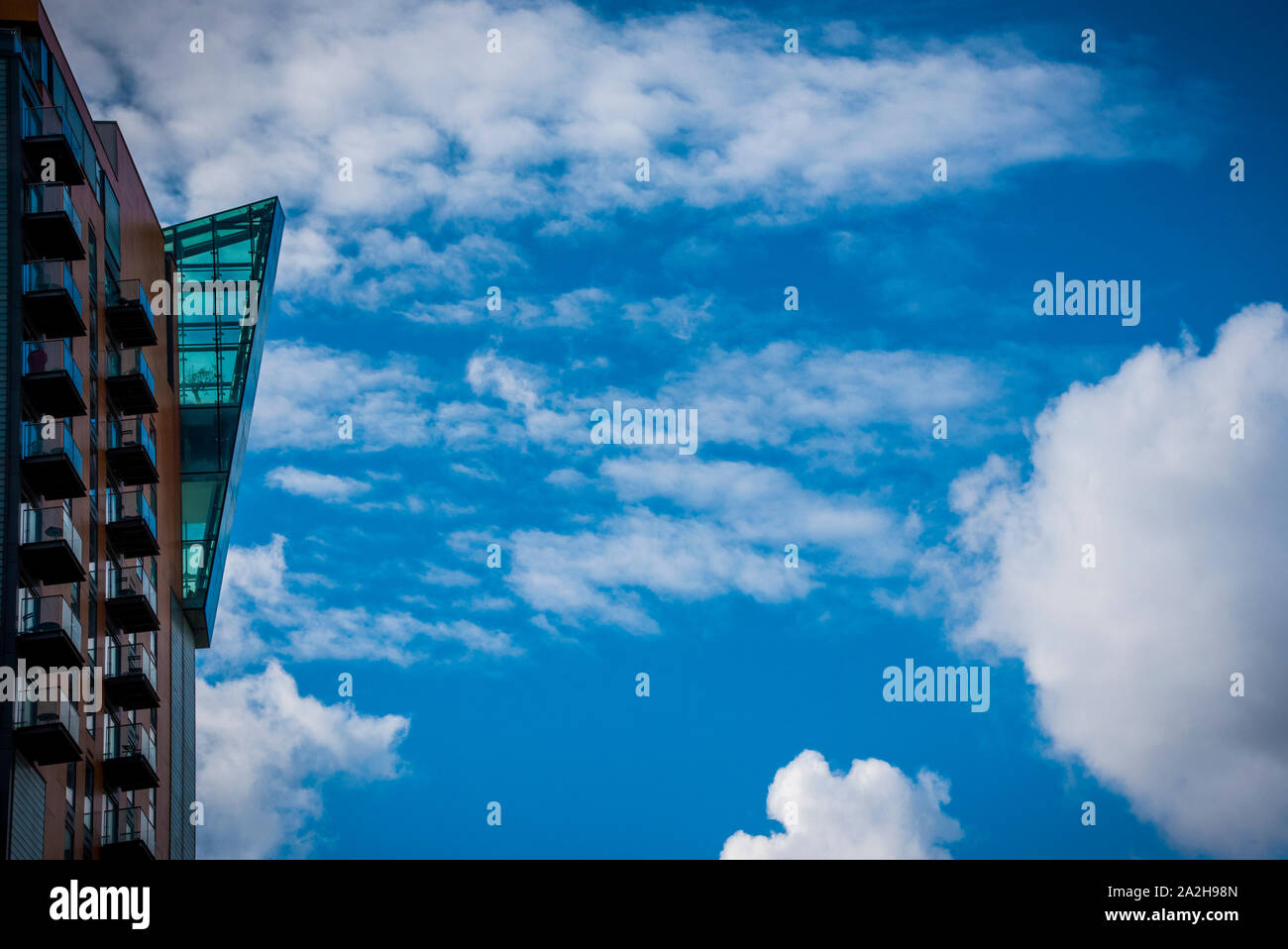 Bâtiment moderne avec des fenêtres en verre sur un ciel nuageux ciel clair à Manchester Banque D'Images