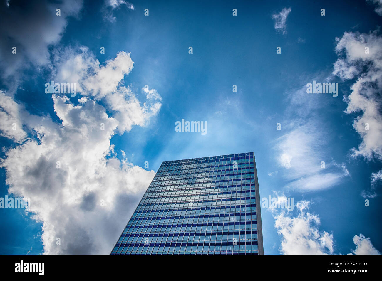 Bâtiment moderne avec des fenêtres en verre sur un ciel nuageux ciel clair à Manchester Banque D'Images