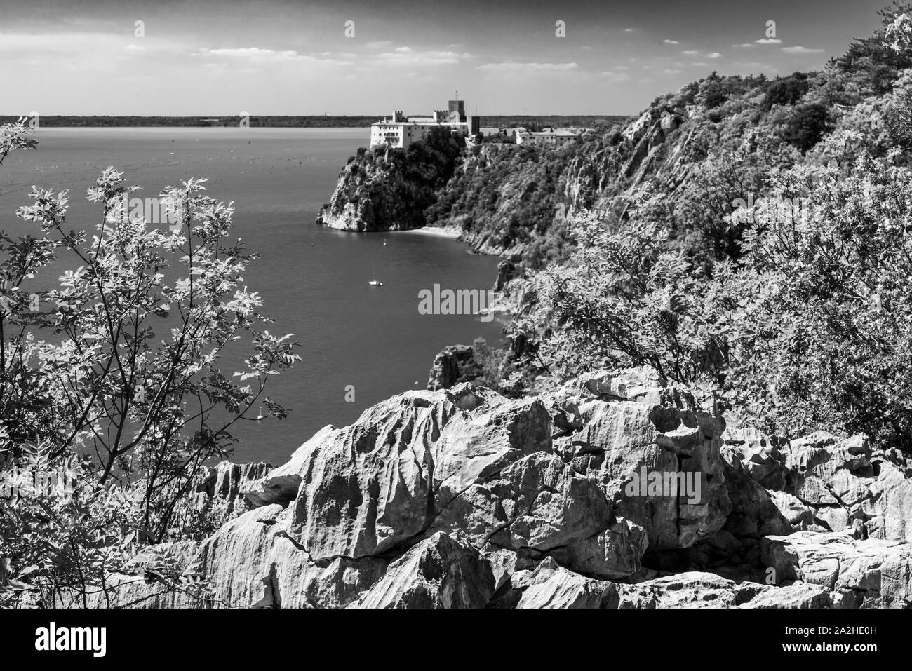 Golfe de Trieste. Hautes Falaises Entre bateaux, les roches karstiques et anciens châteaux. Noir et blanc. Duino. Italie Banque D'Images