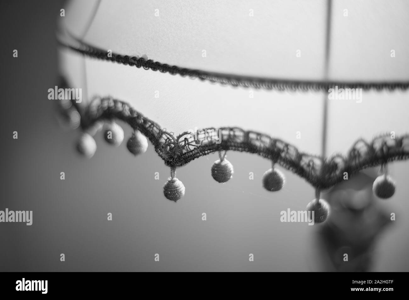 Abat-jour en tissu avec des boules d'or. Close-up, selective focus. Photo NB. Banque D'Images