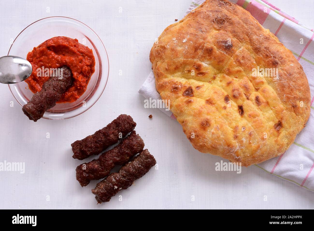 Bosniaque Serbe Croate slave burger, restauration rapide à partir de la traditionnelle cuisine des Balkans - Juicy cevapi faite de viande hachée et servi avec sauce rouge Ajvar Banque D'Images