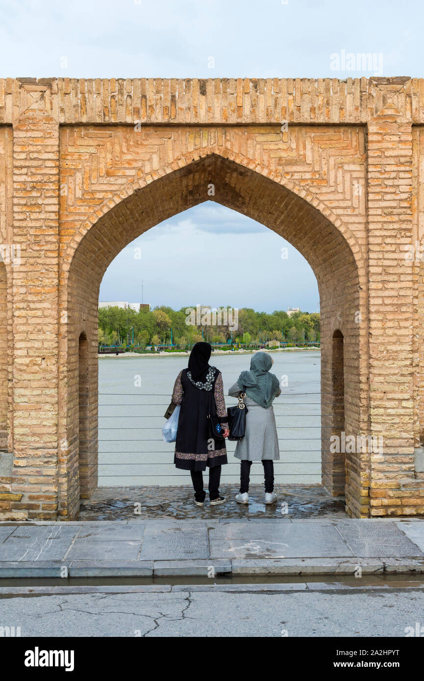Deux femmes iraniennes à la recherche grâce à une arche, Si-o Se pont Allahverdi Khan Pol ou pont sur la rivière Zayanderud, Ispahan, Iran Banque D'Images