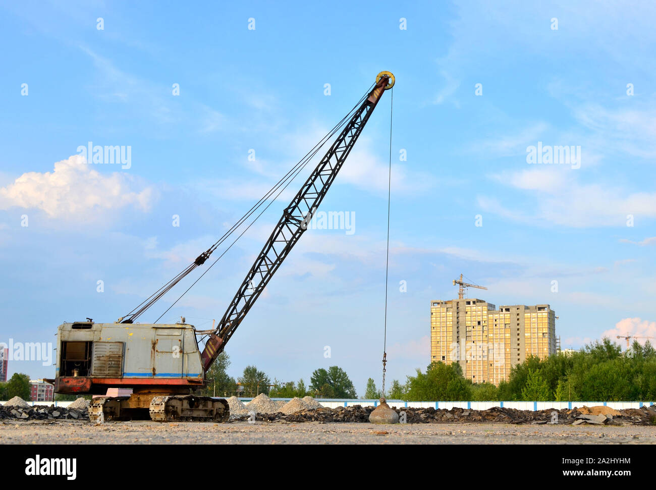 De grandes grues sur chenilles pelle à benne traînante ou avec un métal lourd boulet sur un câble en acier. Wrecking balles sur les chantiers de construction. Démontage et dem Banque D'Images