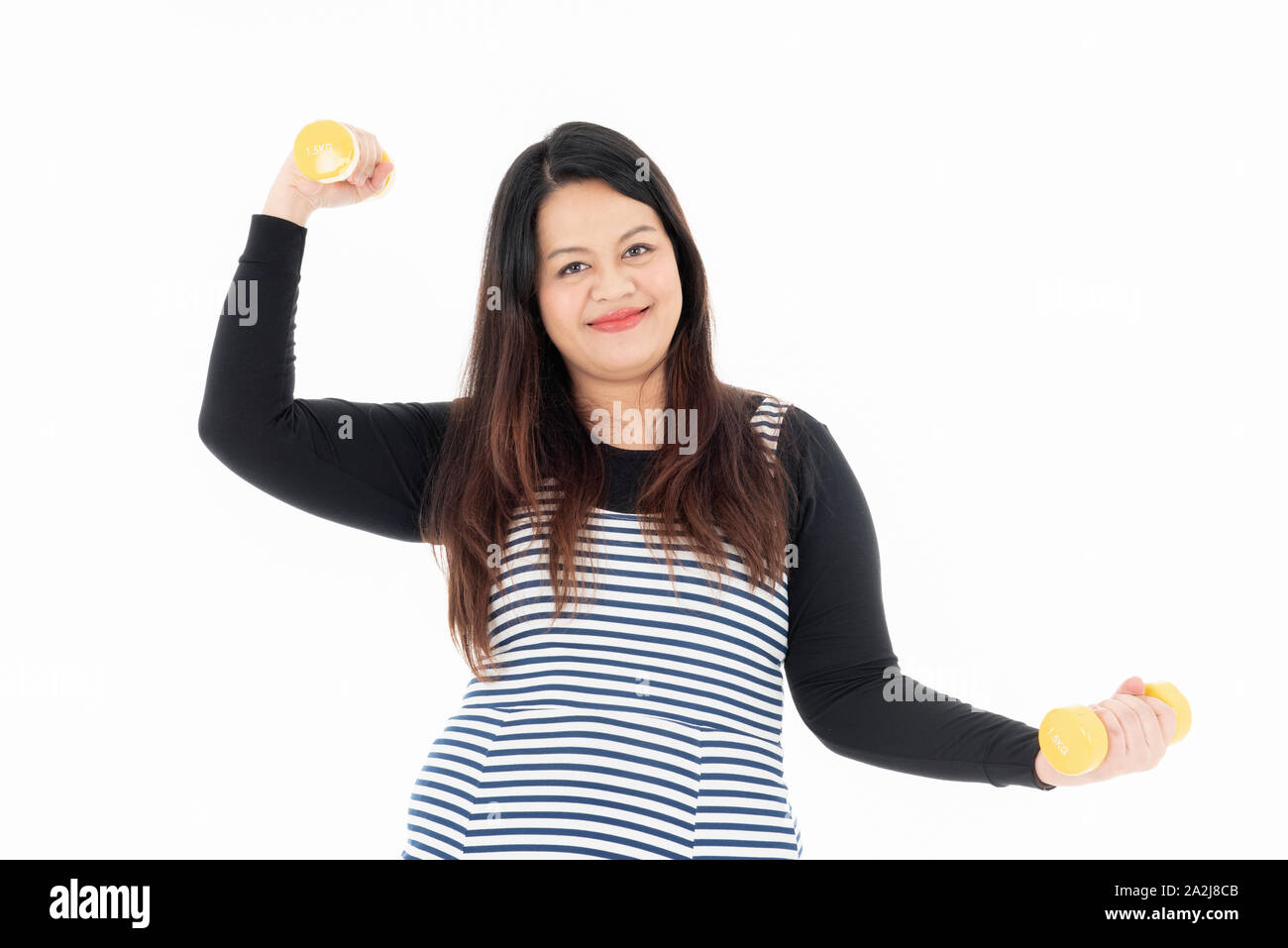 Jeune femme belle de graisse est l'exercice en soulevant des haltères jaune avec les deux mains. Elle sourit et aime perdre du poids pour sa bonne santé. Isolé Banque D'Images