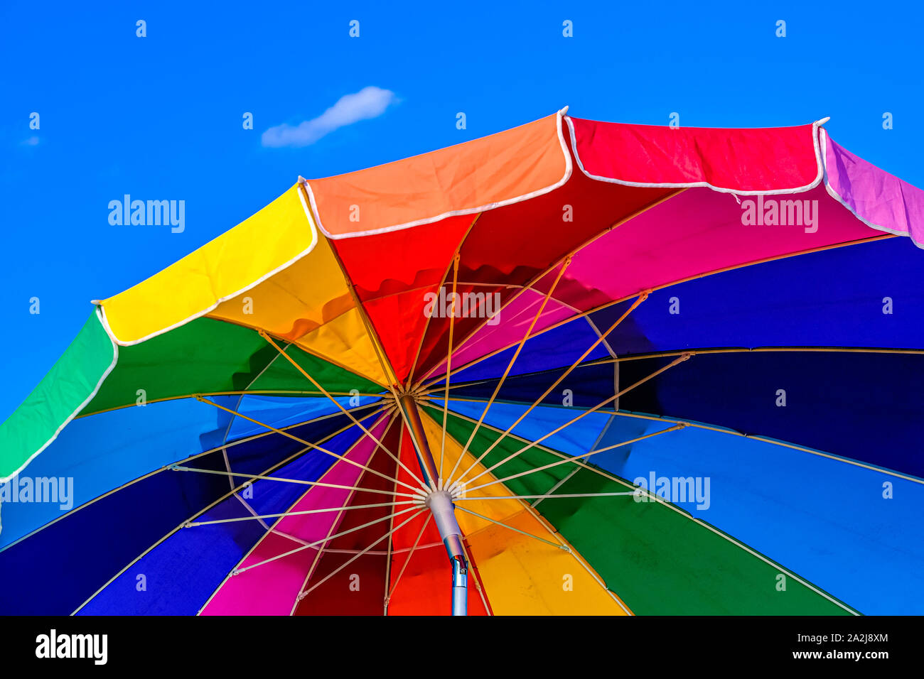 Parapluie coloré contre un ciel bleu Banque D'Images