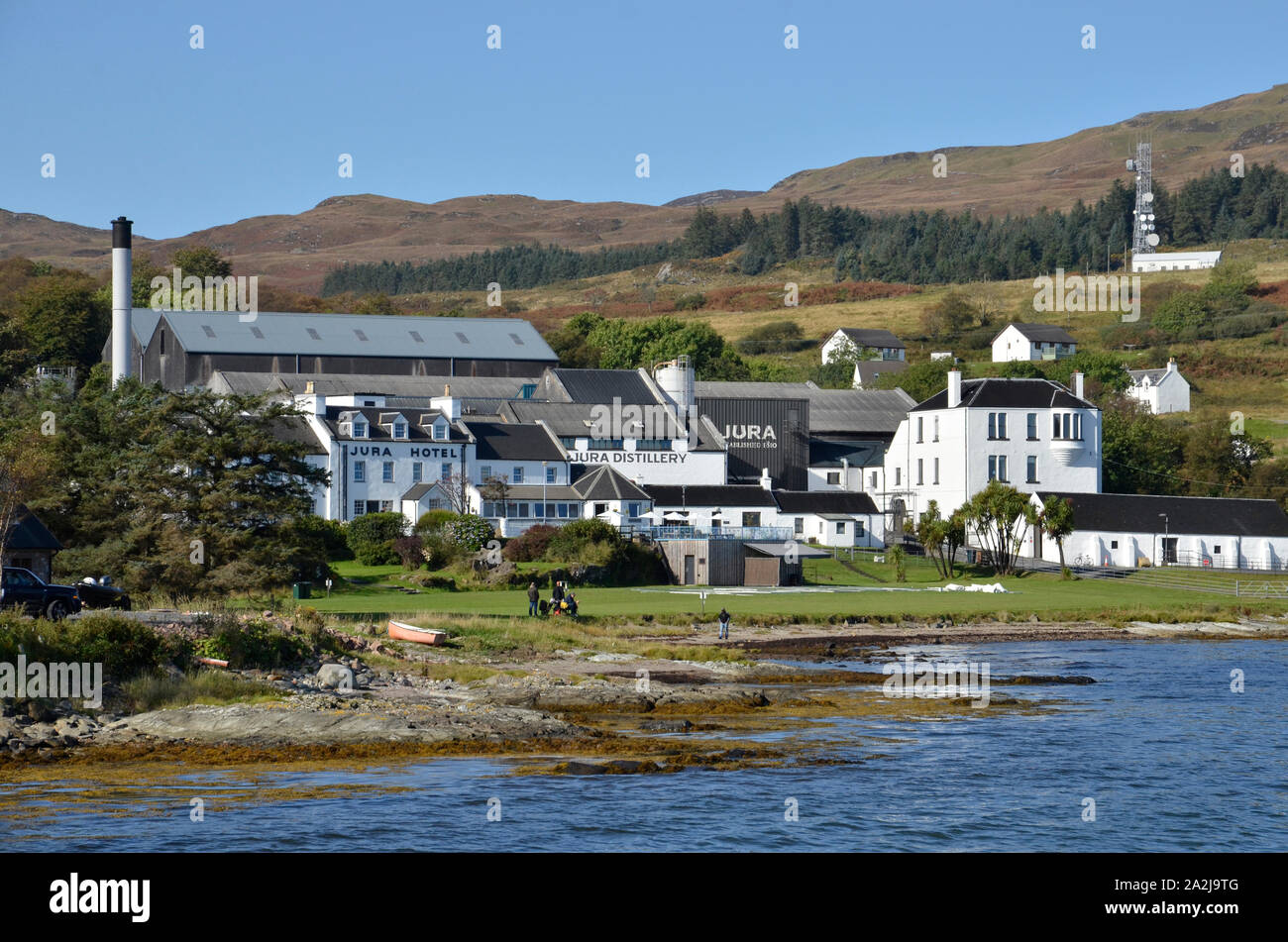 Une vue sur le littoral à Craighouse sur l'île écossaise de Jura avec l'Hôtel Le Jura et Jura Distillery dans le centre Banque D'Images