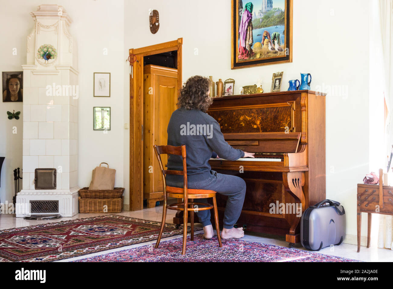 L'homme dans les tenues de jeu Lauberger barefoot & Gloss piano droit  antique classique dans la salle de séjour avec cuisinière, blanc Lőverek,  Sopron, Hongrie Photo Stock - Alamy