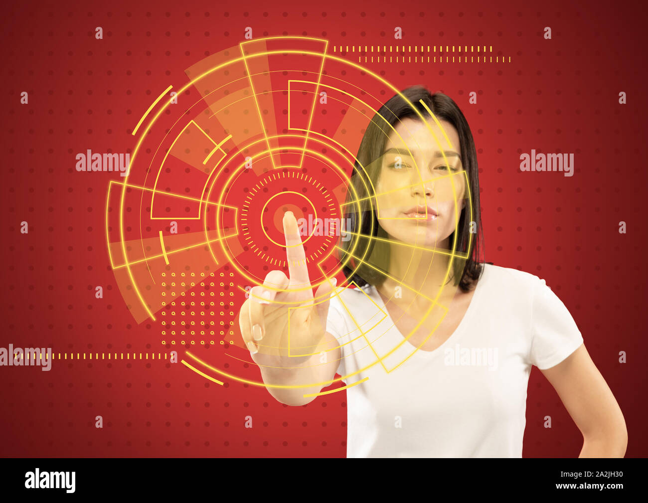 Les technologies modernes. Young caucasian woman's de toucher la réalité virtuelle dans la lumière au néon sur fond rouge. Concept d'émotions humaines, l'expression du visage, gadgets et technologies modernes. Copyspace. Banque D'Images