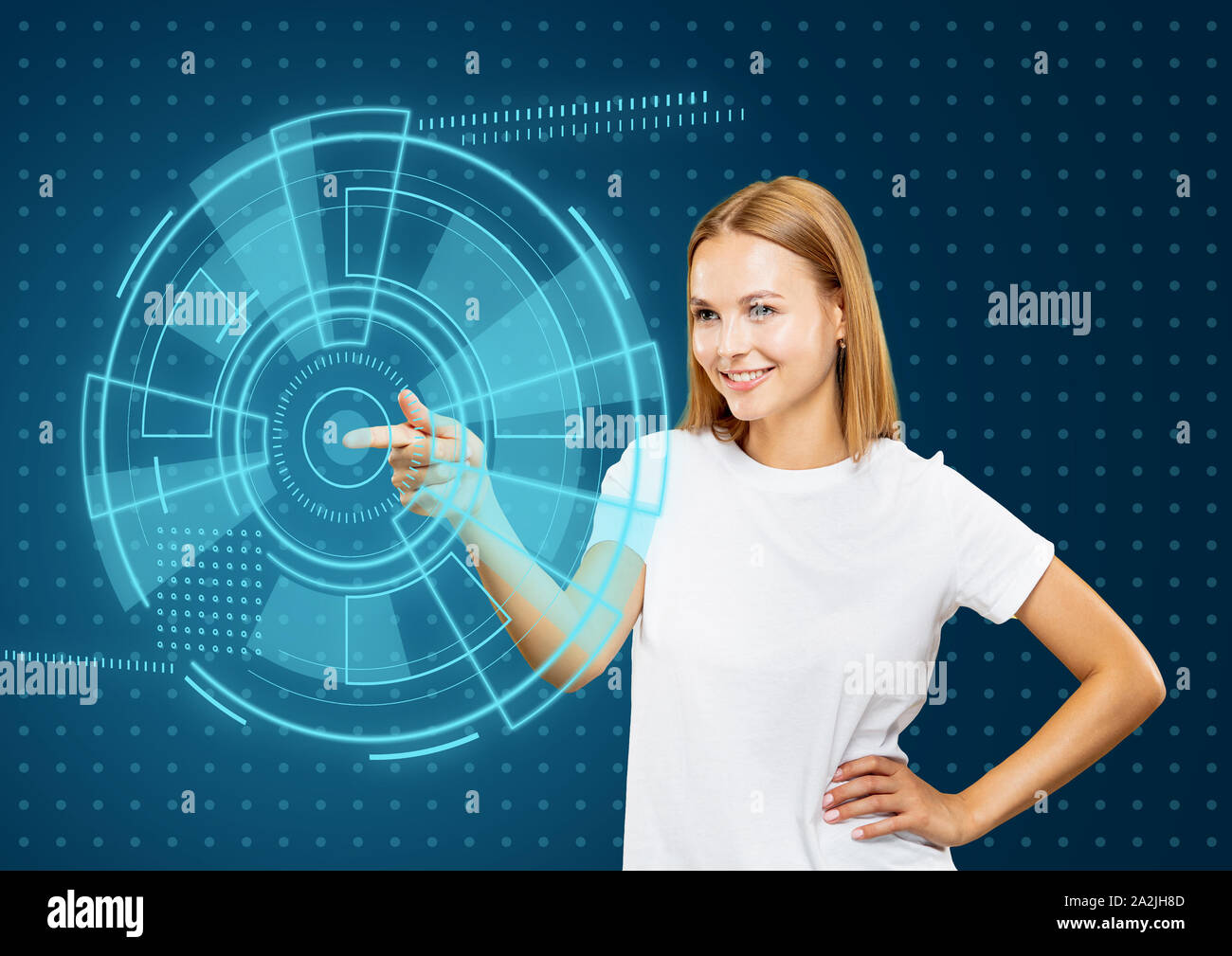 Les technologies modernes. Young caucasian woman's de toucher la réalité virtuelle dans la lumière au néon sur fond bleu. Concept d'émotions humaines, l'expression du visage, gadgets et technologies modernes. Copyspace. Banque D'Images