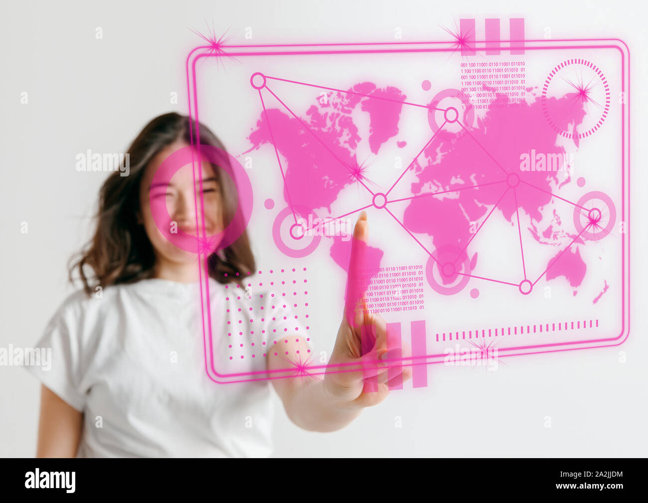 Les technologies modernes. Young Asian woman touche à la réalité virtuelle dans la lumière au néon sur fond rose. Concept d'émotions humaines, l'expression du visage, gadgets et technologies modernes. Copyspace. Banque D'Images