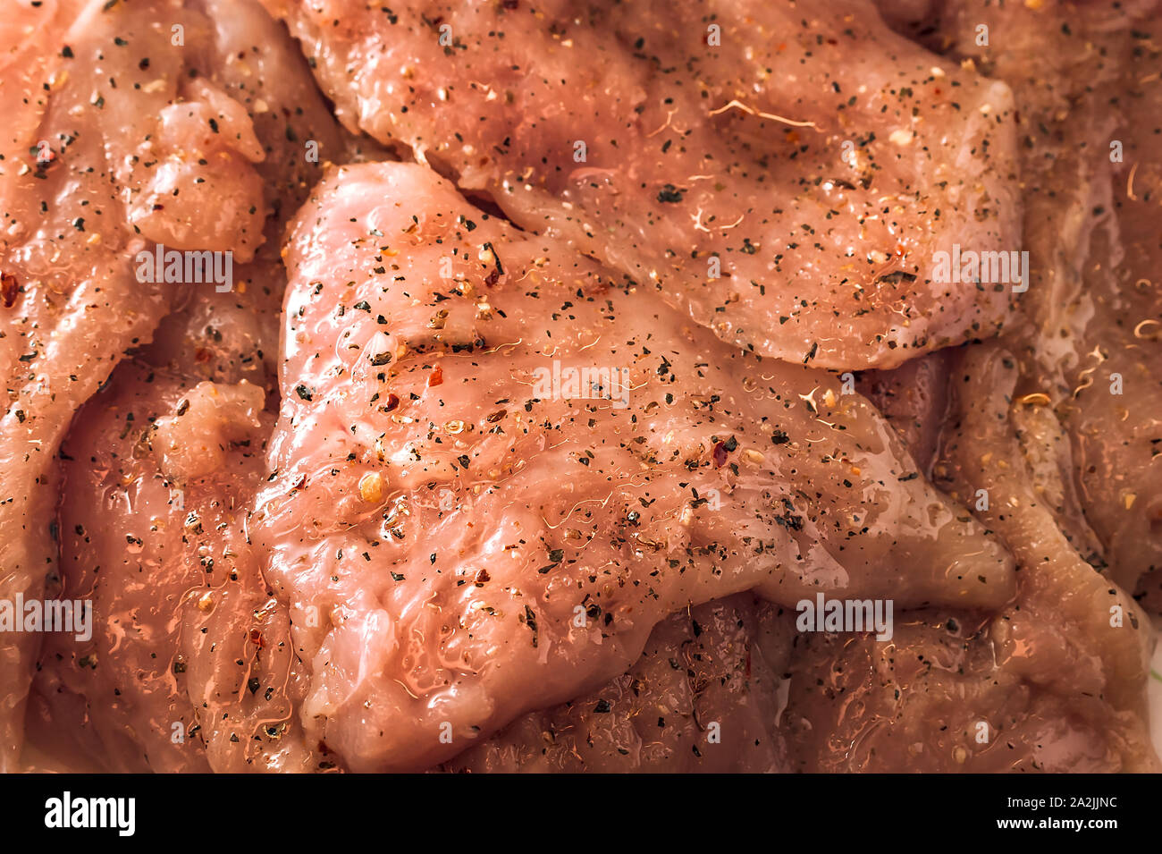 Le poulet cru ou de la viande de dinde filets dans l'huile, l'assaisonnement et les épices. Banque D'Images