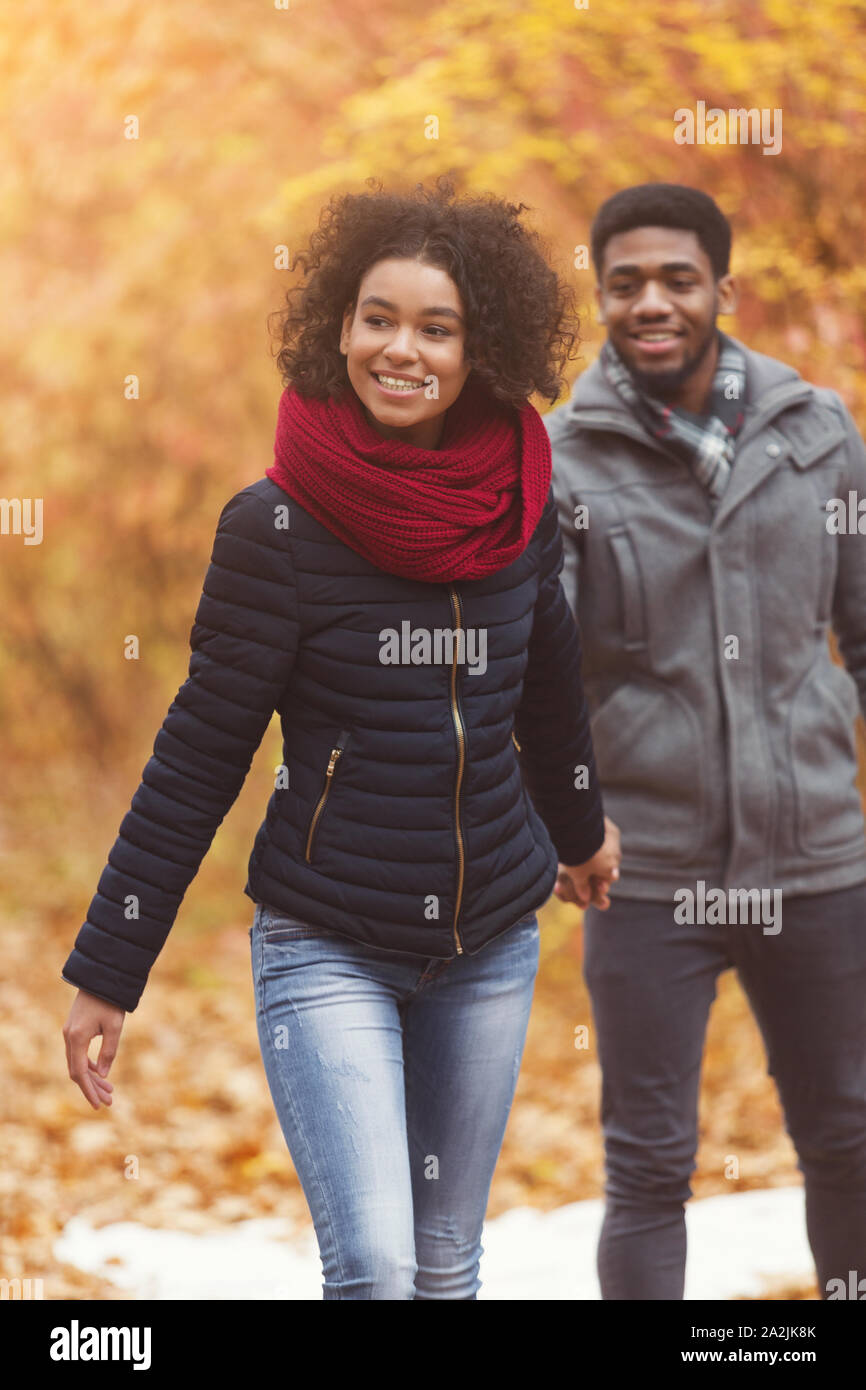 Marche d'automne. Homme heureux à la suite de petite amie, walking in park Banque D'Images