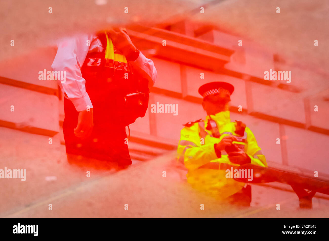 HM Treasury, Westminster, London, UK. 06Th Oct, 2019. Les agents de police sont reflétées dans une flaque de sang rouge faux extérieur HM Treasury. Rébellion Extinction manifestants ont pulvérisé l'extérieur de l'immeuble du Trésor à Westminster avec faux sang de la durit d'une friche à incendie et sont arrêtés sous forte présence policière. Credit : Imageplotter/Alamy Live News Banque D'Images