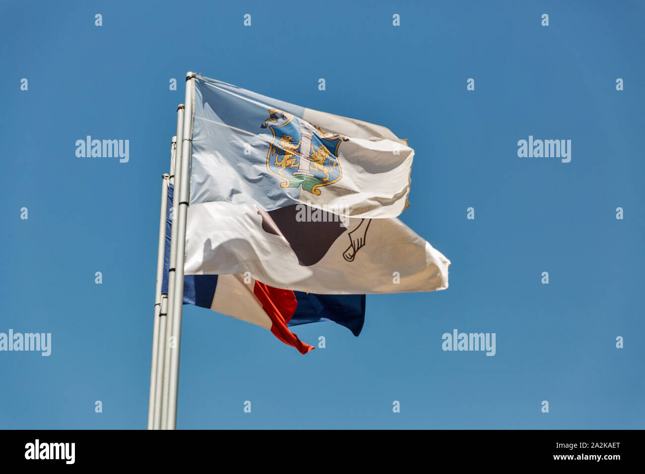 Brandissant des drapeaux d'Ajaccio, Corse, France et l'Union européenne contre le ciel bleu clair Banque D'Images