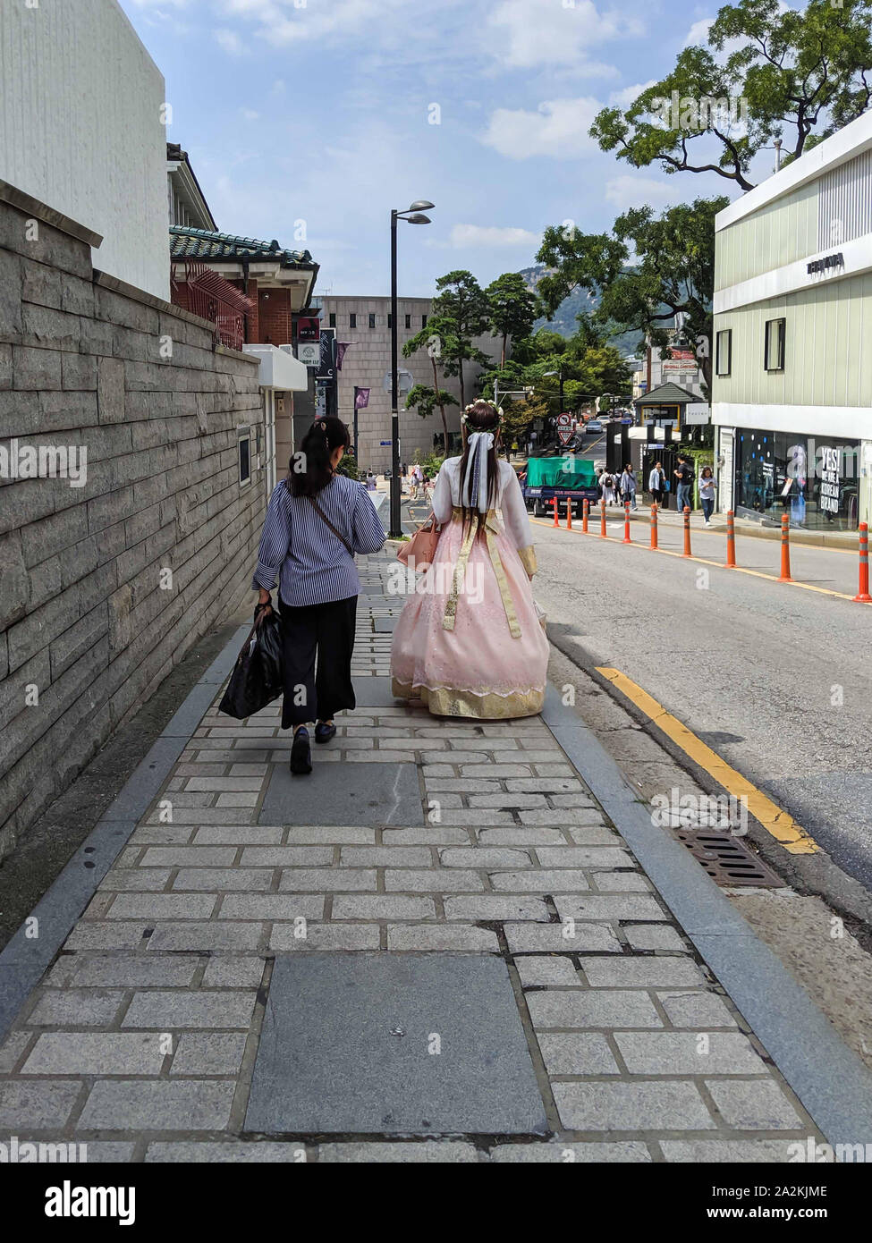 SEPT. 19, 2019-Séoul CORÉE DU SUD : Yougn femme vêtue avec une robe hanbok traditionnel coréen à marcher avec une femme portant un des vêtements modernes. Promenade Banque D'Images