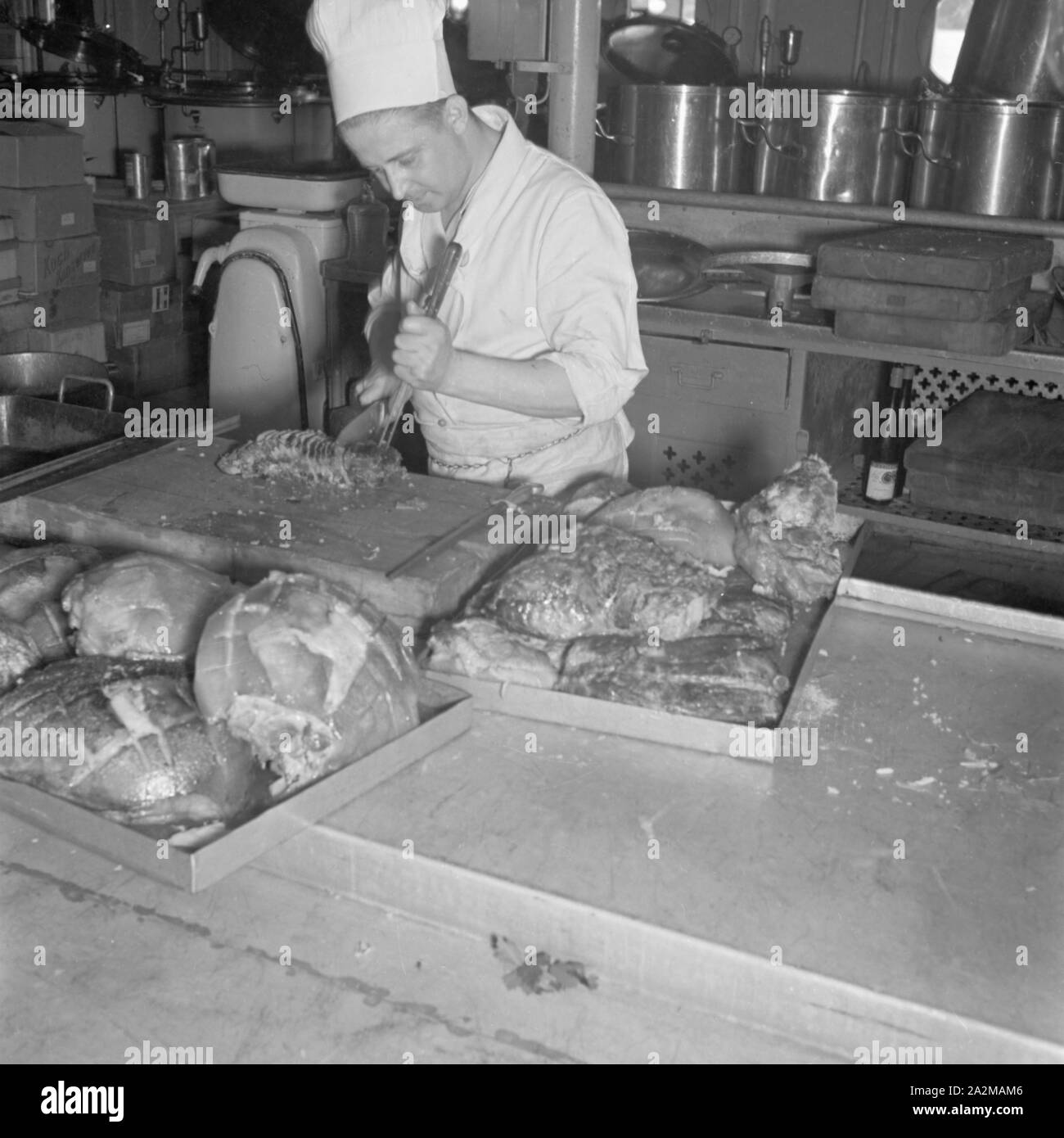 Original-Bildunterschrfit : Der koch tranchiert - wie in Zeiten friedlicher KdF-Reisen - ein paar Dutzend Schweinebraten, ebenso für die sorgfältig Verwundeten zubereitet wie für die KdFUrlauber An Bord der 'Wilhelm Gustloff', Deutschland 1940er Jahre. La préparation de certains Chef de porc - qu'en temps de paix au navire 'Wilhelm Gustloff', l'Allemagne des années 40. Banque D'Images