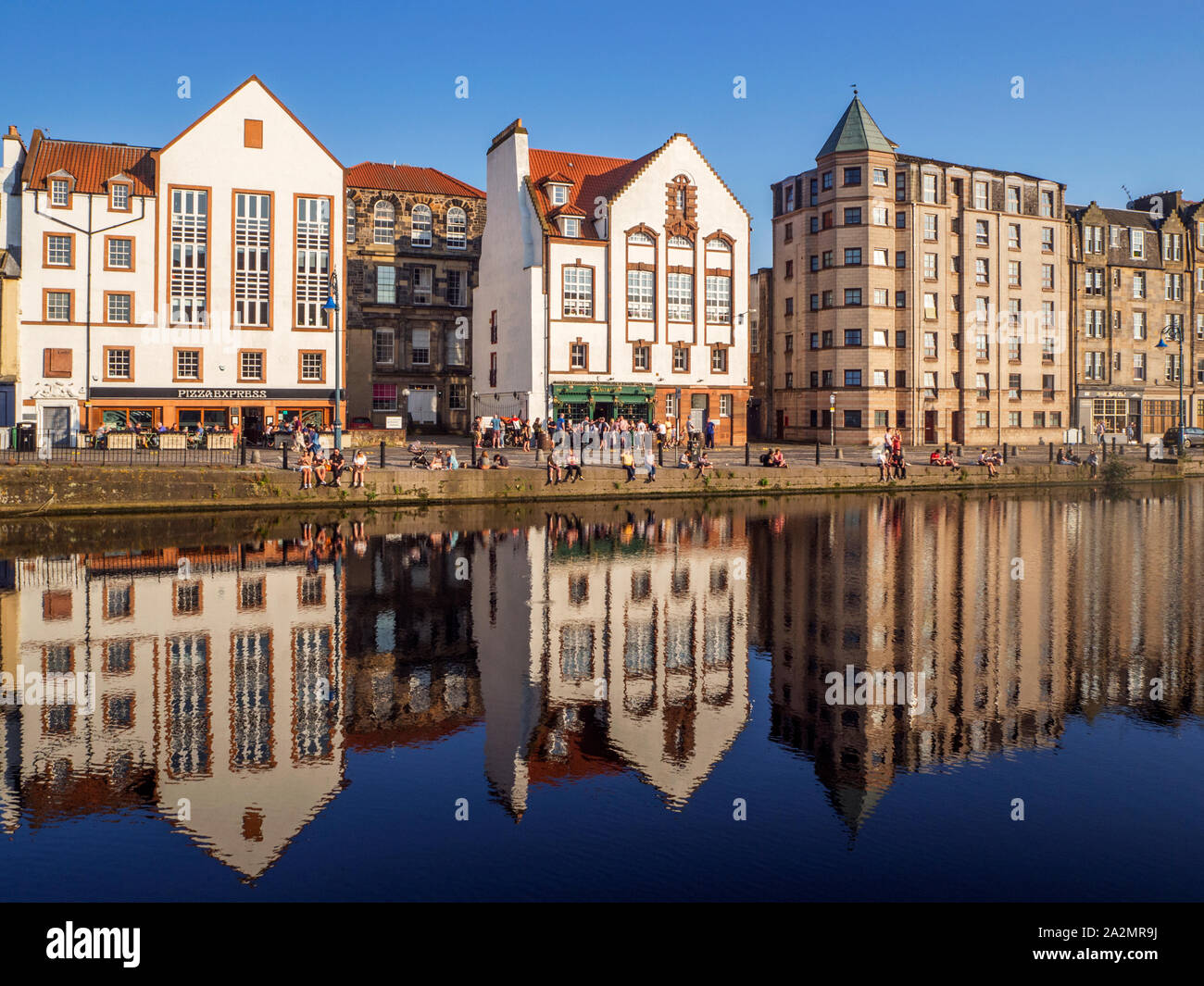 Vieux bâtiments le long du rivage reflète dans l'eau de Leith Leith un soir d'été Ville d'Edimbourg en Ecosse Banque D'Images