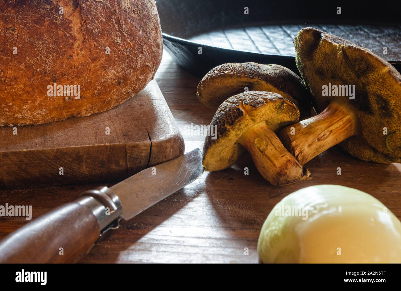 Nature morte au pain et oignon champignons couteau en attente d'être cuite pour le dîner dans une poêle de fer Banque D'Images