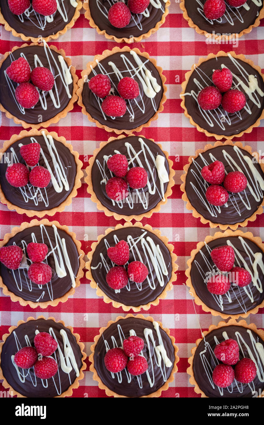 Tartelettes au chocolat et framboise sur un fond Vichy Banque D'Images