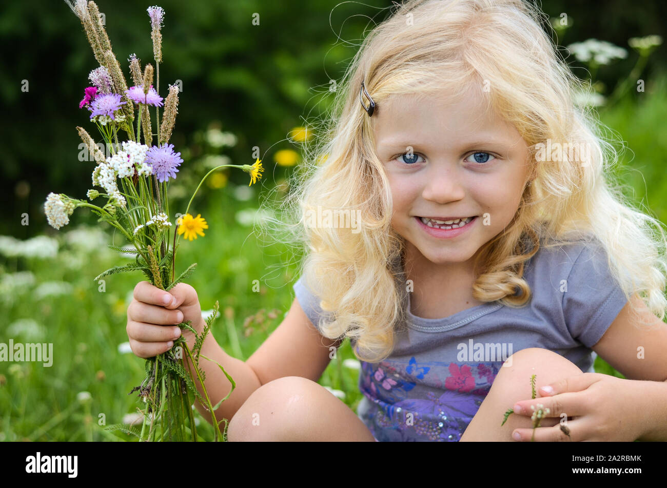 Fille blonde avec des fleurs à la main Banque D'Images