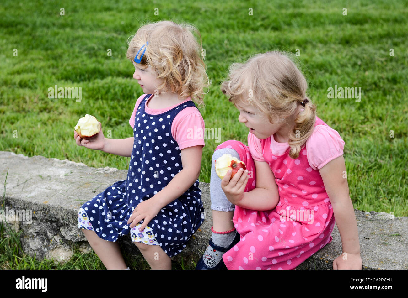 Deux blondes de manger une pomme Banque D'Images