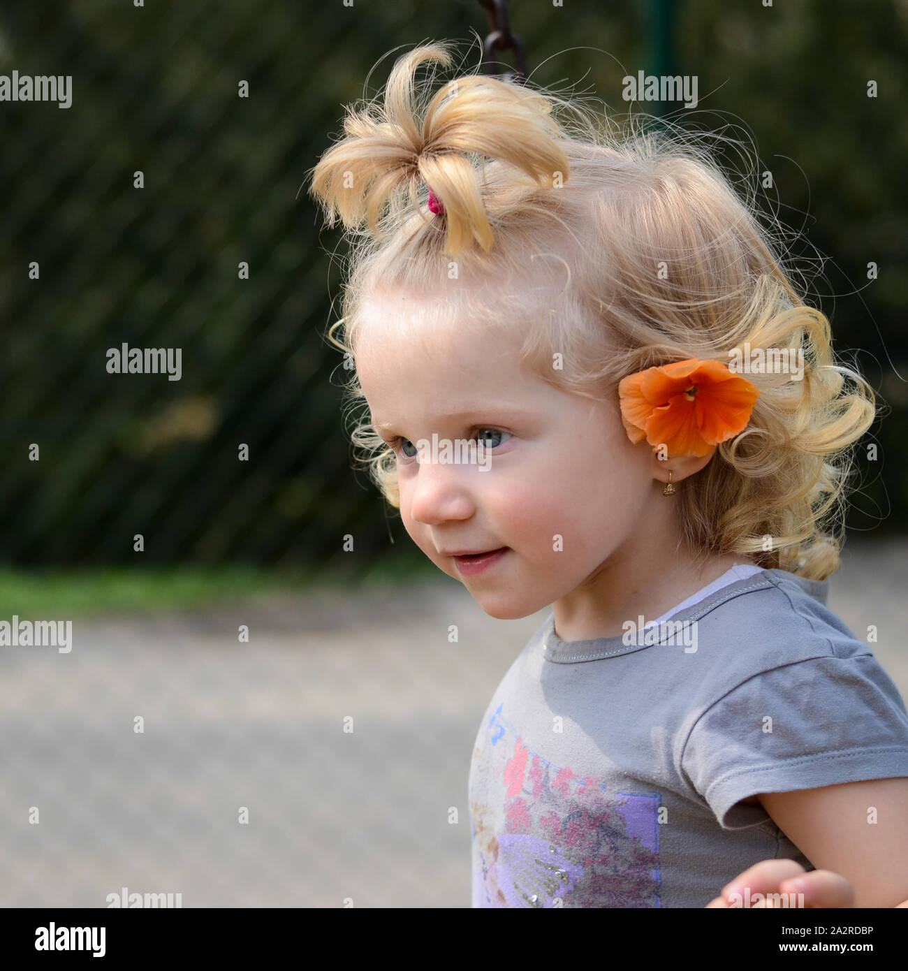Fille blonde avec une fleur orange Banque D'Images