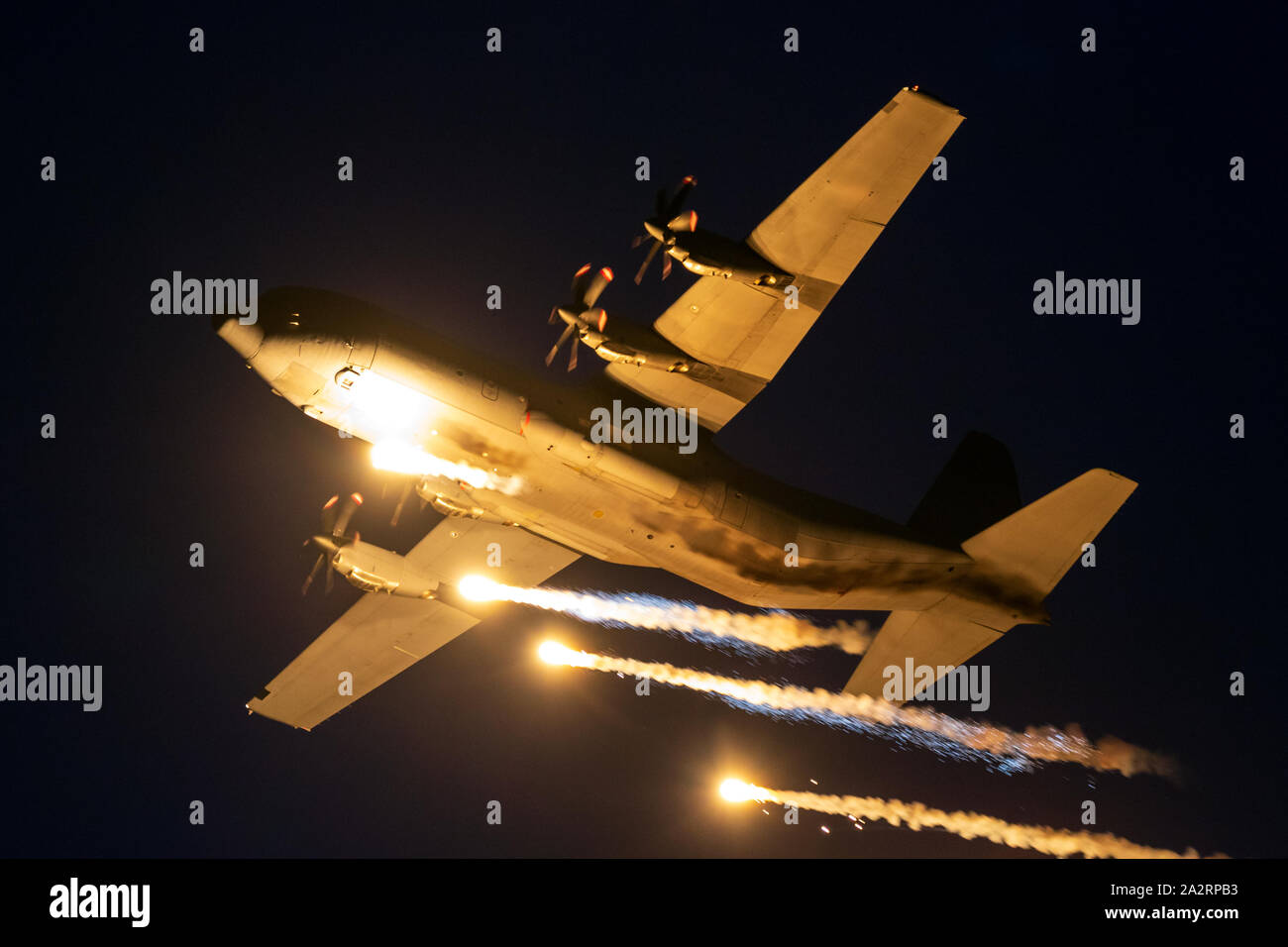 SANICOLE, BELGIQUE - Sep 13, 2019 : Danish Air Force Lockheed C-130 Hercules avion militaire tirant des fusées éclairantes dans l'obscurité à l'Sanice Sunset Airshow. Banque D'Images