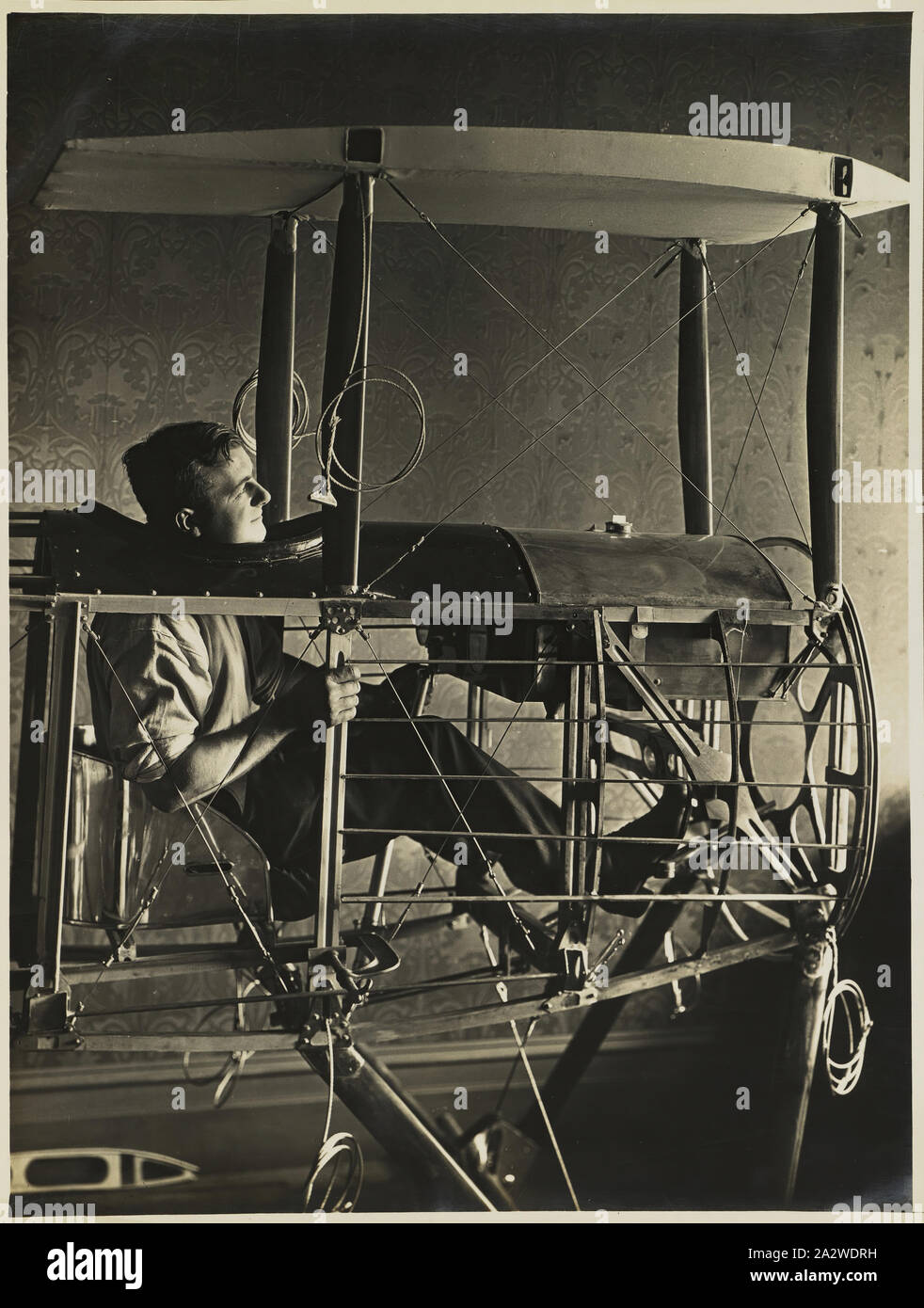 Photographie - Basil Watson assis dans le cockpit du fuselage biplan partiellement construite dans la maison familiale, Elsternwick, Victoria, 1916, partie d'un album de photographies commémoratives produites par les studios de Sears, Melbourne, documentant le travail de basilic dans la construction d'un biplan Watson chez lui, 'Foilacleugh' dans Elsternwick, Victoria, au cours de 1916, et la suite de son accident mortel au large de Point Cook le 28 mars 1917. Le biplan était basé sur la conception du Sopwith Pup Banque D'Images