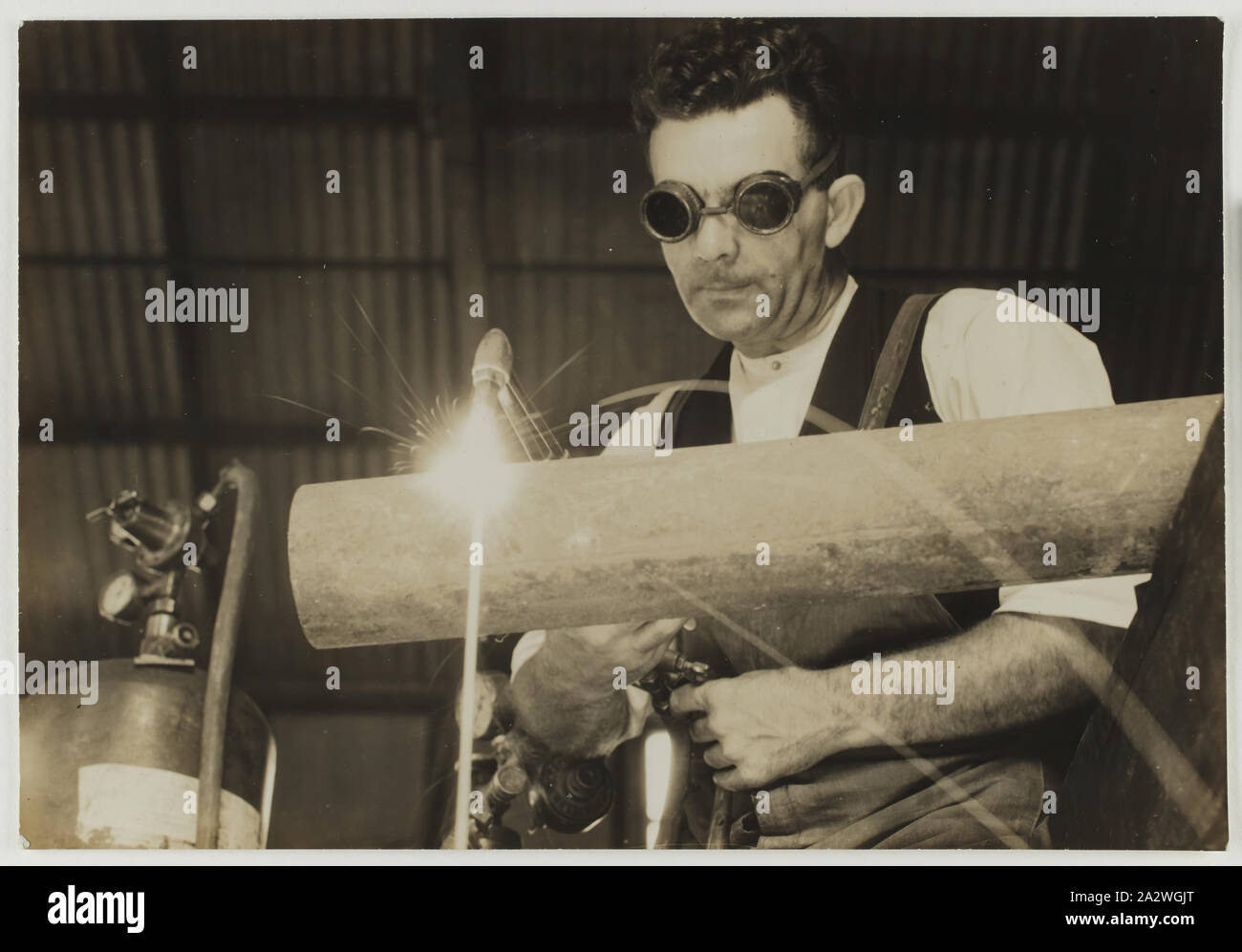 Photographie, Jim Myers tuyau soudure, Abbotsford, Victoria, 1930, photographie monochrome de Jim Myers, un ancien employé d'Australasie Kodak, oxy acétylène de souder un tuyau dans l'ateliers de l'usine Kodak à Abbotsford, Victoria, vers 1930 Banque D'Images