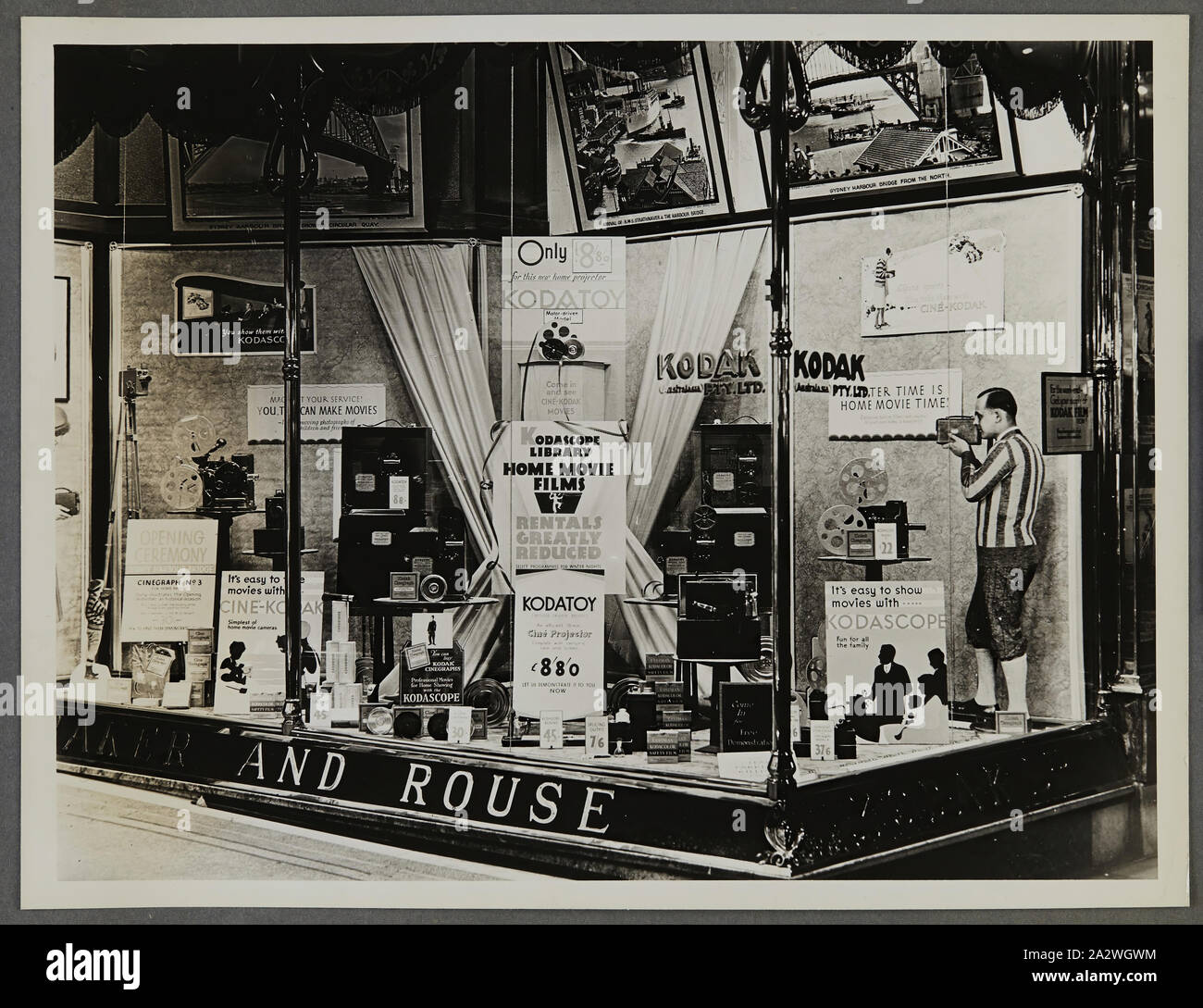 Photographie - Kodak, des passants, l'affichage 'Kodascope Accueil Films Film', vers 1934-1936, des passants afficher 'Kodascope Accueil Films film montrant des caméras, des photographies, des accessoires et de l'équipement photographique. L'une des cinquante-six photographies dans un album illustrant Australasia Pty Ltd Kodak shop/fenêtre affiche depuis le milieu des années 1930. En général Windows produits en vedette promotions pour film ou des appareils photo, ainsi que des expositions de photos pour attirer les foules au magasin. Expositions Banque D'Images