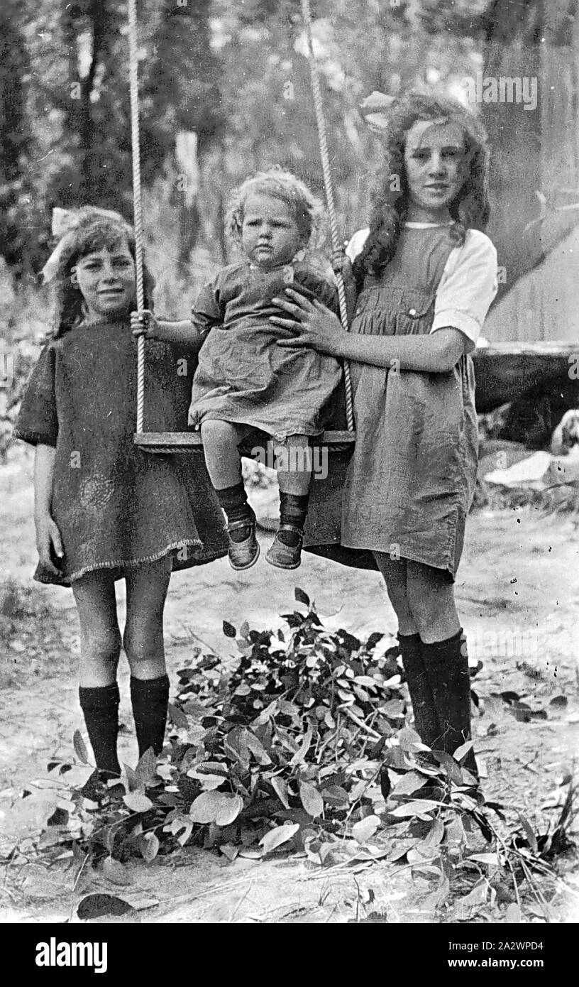 - Négatif le Boronia, Victoria, 1924, deux jeunes filles tenant un enfant sur une balançoire. La balançoire semble être très élevé et un tas de feuilles a été construit sous l'oscillation Banque D'Images