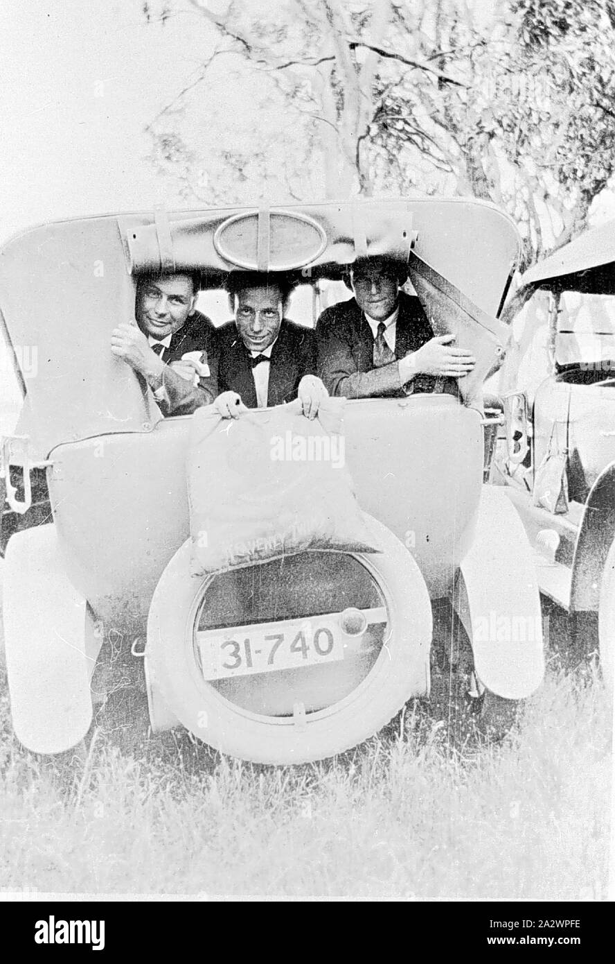 Négatif - Barham, New South Wales, 1930, trois hommes regardant par la fenêtre arrière d'une voiture à moteur Banque D'Images Négatif - Barham, New South Wales, 1930, trois hommes regardant par la fenêtre arrière d'une voiture à moteur Banque D'Images