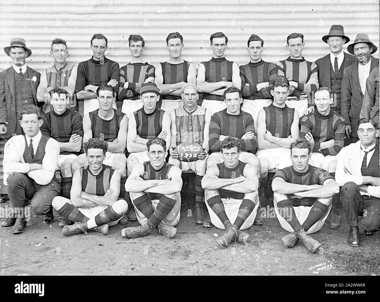 Négatif - Victoria, 1922, une équipe de football. La tenue de football par la figure centrale porte les mots : 'Faughs 1922 Banque D'Images