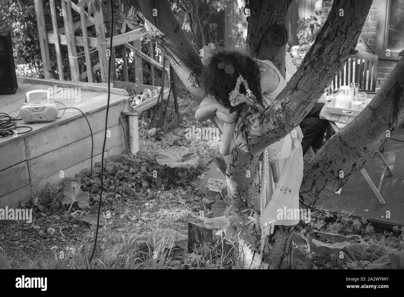 Une statue d'une fille se tient dans un cimetière dans une forêt gris pendant la journée et est triste Banque D'Images