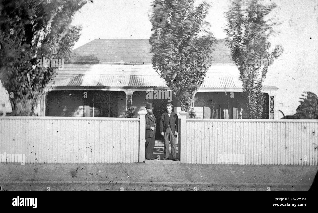 Négatif - Port Melbourne, Victoria, 1879, deux hommes, à la porte d'une maison. La clôture est ondulée et il y a trois arbres en face de la maison Banque D'Images