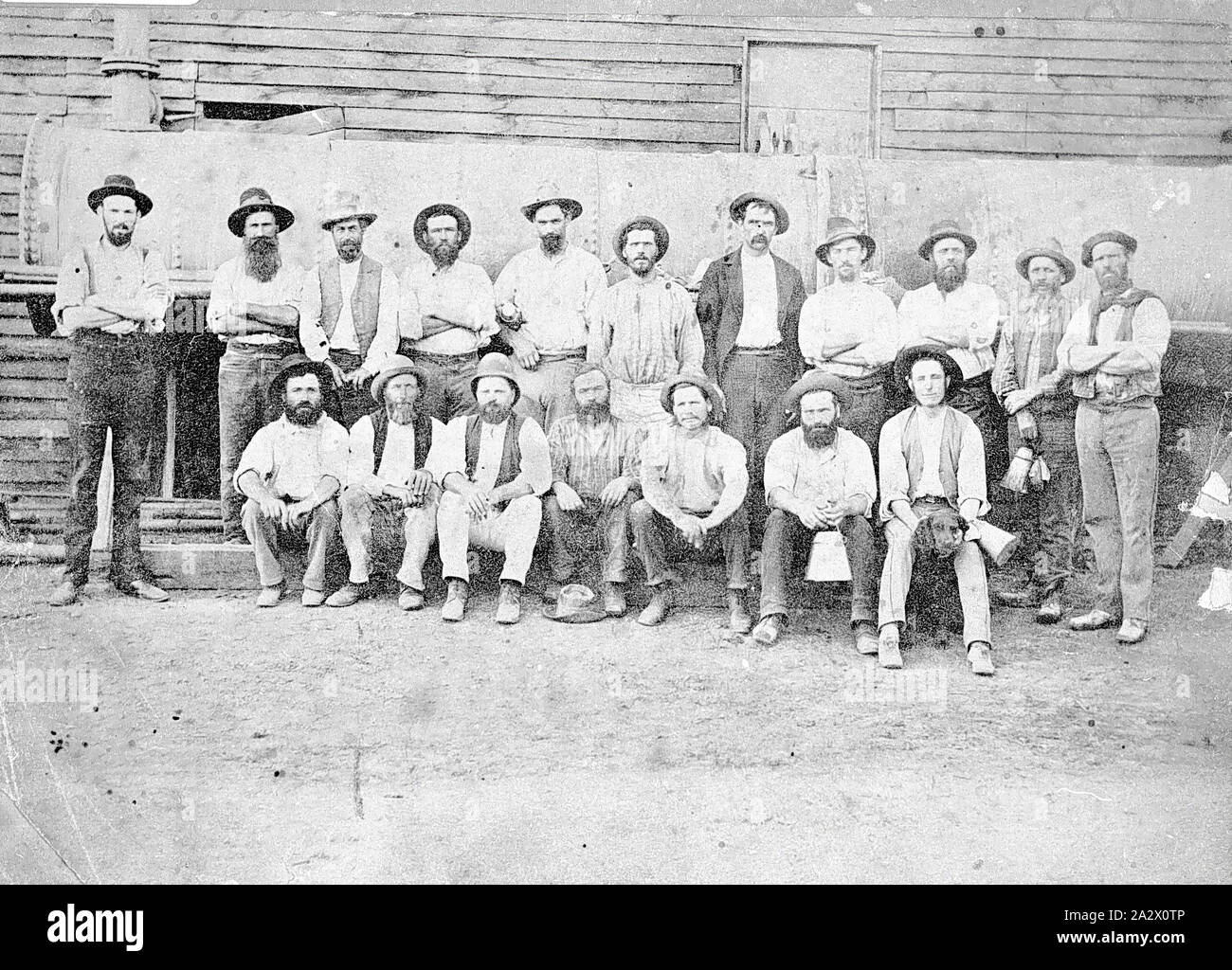 Négatif - Bendigo, Victoria, vers 1895, un groupe de mineurs de la mine de St Mungo. Ils sont debout en face de la chaudière vapeur. Un homme est titulaire d'un chien Banque D'Images
