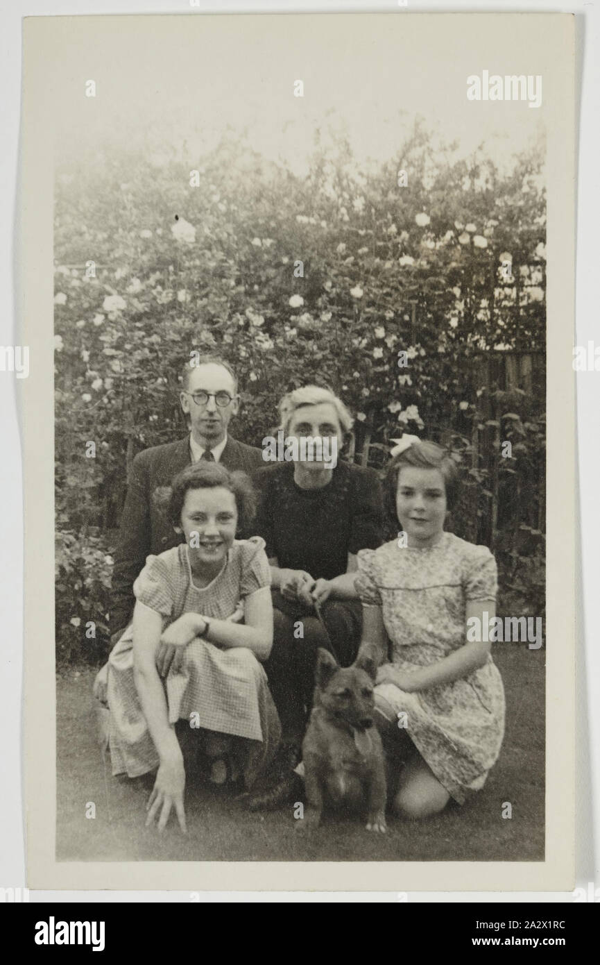 Photographie - Palmer dans la famille Jardin, Iver, en Angleterre, vers 1947, Photographie noir et blanc Photographies de George et de Gertrude Palmer, leurs filles Shirley et Lesley, et de leur chien Robbie, en Angleterre autour de 1947. Il a probablement été prise à la George's Sister's house en Iver, Buckinghamshire par George's beau-frère David Roberts. Il a été porté à l'Australie par George Palmer lorsqu'il a émigré en Australie depuis l'Angleterre avec sa femme Rita et leurs deux filles, Shirley Banque D'Images