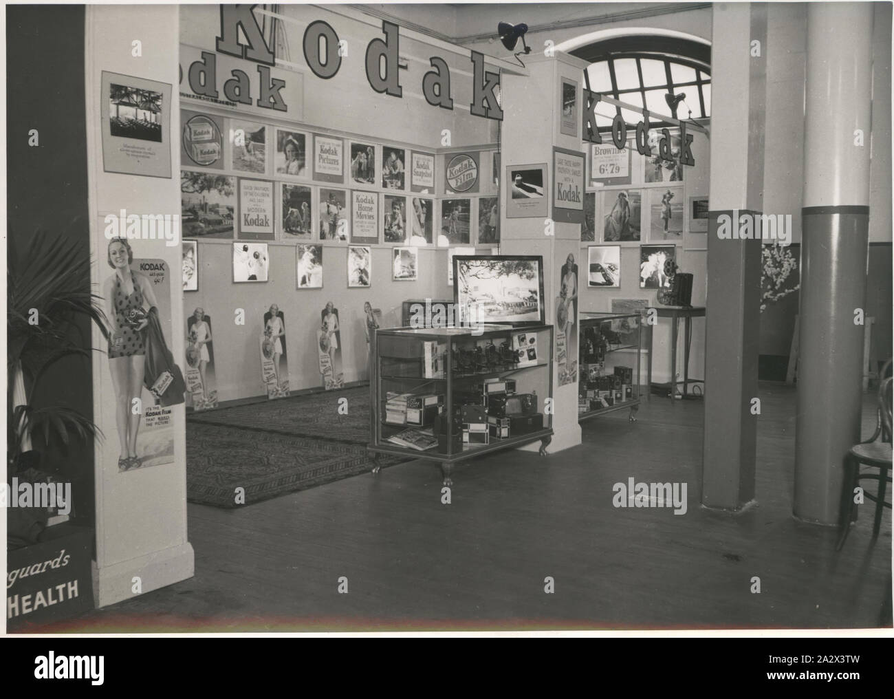 Photographie, Stand, exposition de l'enfance, vers 1930, photographie d'un monochrome Kodak Australasia Pty Ltd stand à un salon de l'enfance, vers 1930. L'écran est doté d'un certain nombre de photographies des affiches et des slogans publicitaires, ainsi que des comptoirs de verre plein d'appareils photo numériques et accessoires. Slogans : "Bon d'instantanés de l'enfant est facile avec un Kodak moderne', 'enregistrer ces sourires avec un Kodak jeune', et 'c'est un Kodak Banque D'Images