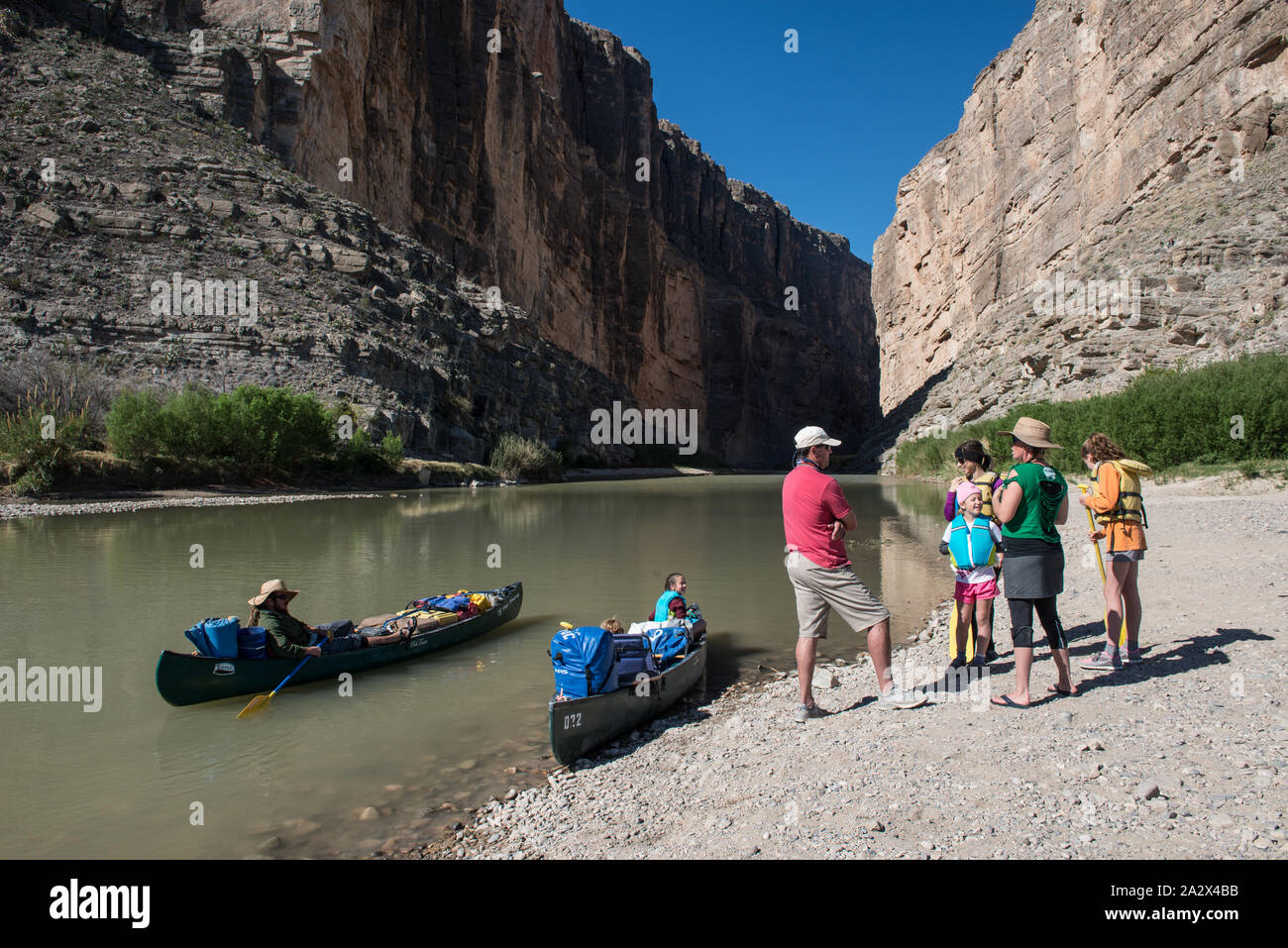 Le major à la retraite-league baseball star Lance Berkman, dans la chemise rose, et sa famille, conférer avec guides de la rivière lointaines-tour company avant de partir sur un voyage en canot à travers Santa Elena Canyon, profondément dans le parc national Big Bend dans Brewster County, Texas. Les murailles abruptes du Mexique sont à la gauche, ceux des États-Unis vers la droite Banque D'Images