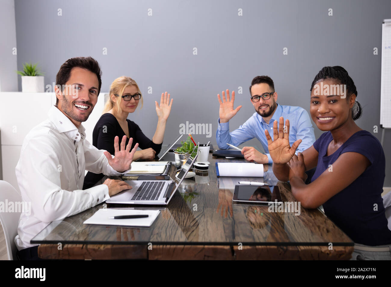 Happy Young Businesspeople des signes avec la main lors d'une réunion dans le bureau de la conférence Banque D'Images