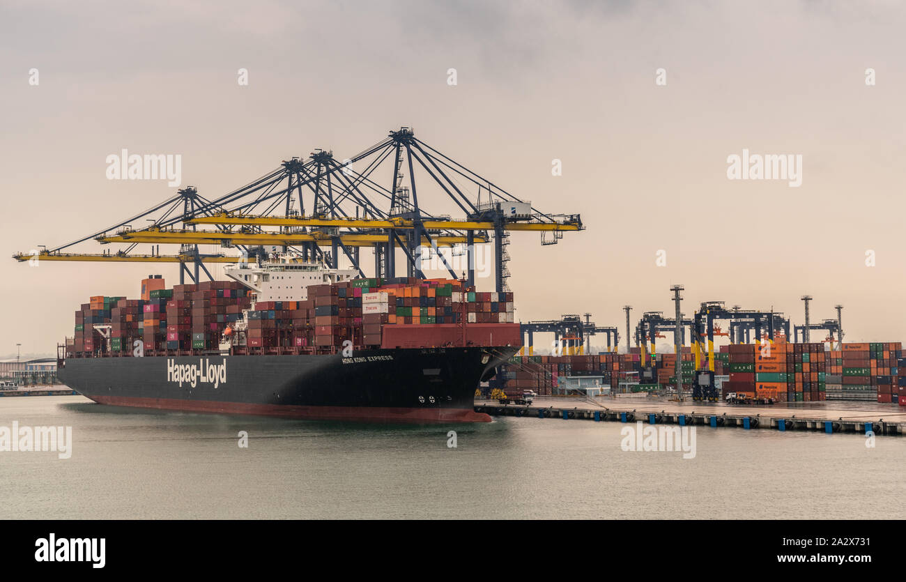 Laem Chabang, Thaïlande - Mars 16, 2019 : le port et le terminal à conteneurs et Hapag Lloyd navire sous ciel gris. Chargement et déchargement grues jaunes. Colo Banque D'Images